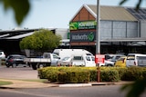 The exterior of a suburban shopping centre with a sign for Woolworths