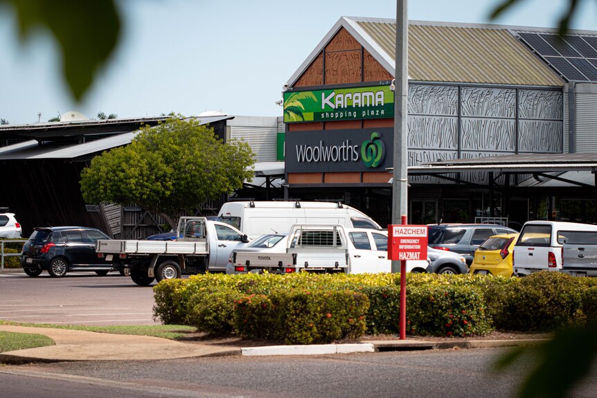 The exterior of a suburban shopping centre with a sign for Woolworths