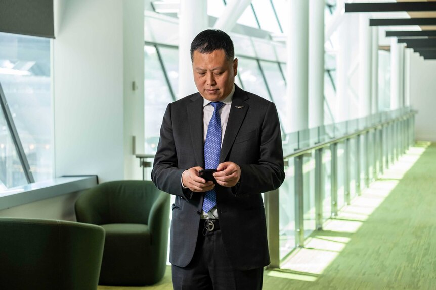 Huifeng Liu looks at his phone.