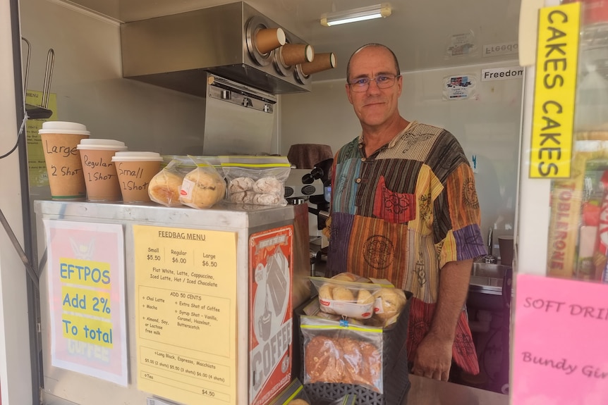 A mid shot of a man standing behind the counter of a coffee van