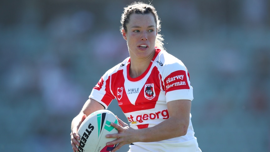 A St George Illawarra NRLW player holds the ball in two hands during a match.