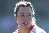 A St George Illawarra NRLW player holds the ball in two hands during a match.