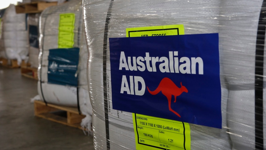 Pallets of supplies labelled AusAID with a kangaroo logo