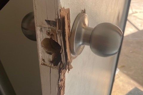 a broken keyhole and splintered timber door