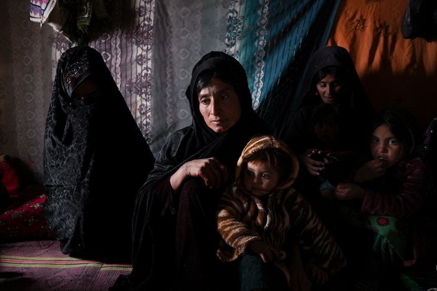 When in Afghan clothing sit on the floor with their children.