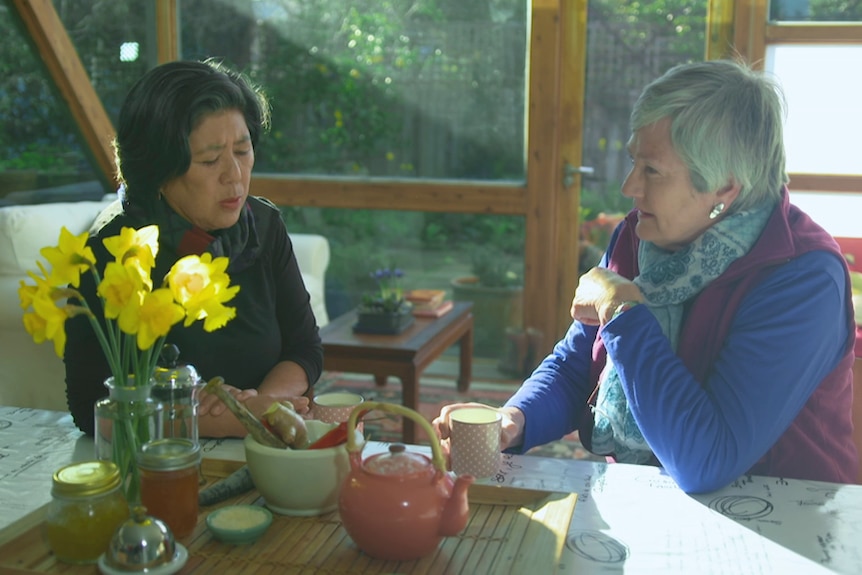 Two ladies chat over a cup of tea