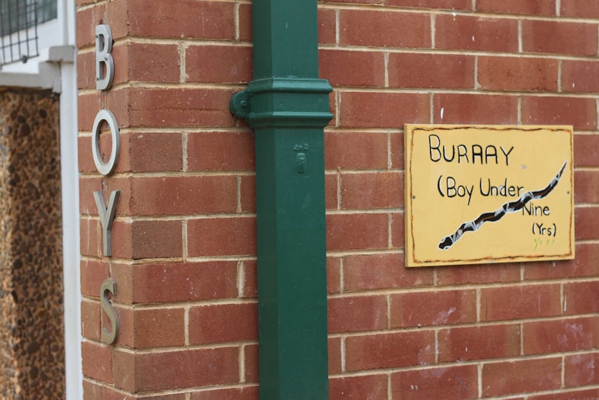 A sign in Wiradjuri reading "burray" is displayed outside the boys' toilets at Parkes East Public.