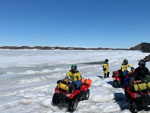 Antarctic team members on quad bikes on ice