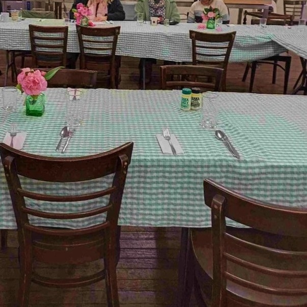 people sitting at a table in a church hall 