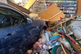 A car crashed into a shop with wool and craft supplies scattered around it. 
