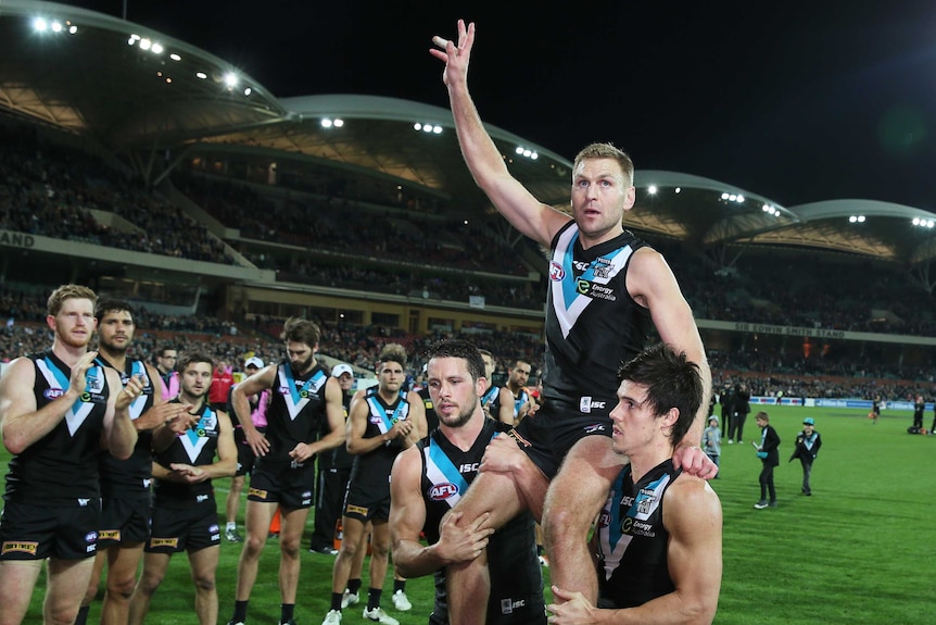 Port Adelaide's Kane Cornes is chaired off by team-mates after his final AFL game against Richmond.