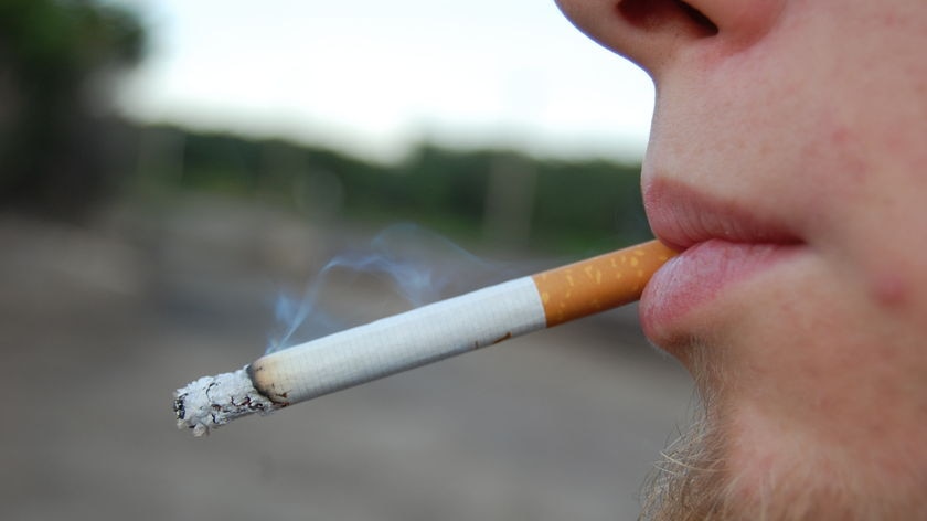 A teenage boys smokes a cigarette