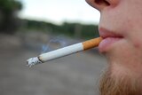 A teenage boy smokes a cigarette