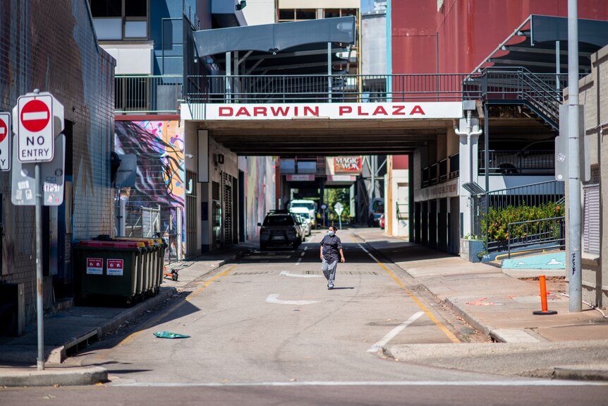 A person dressed as a chef walks down an empty back street in the Darwin CBD.