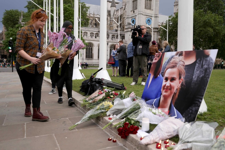 Floral tributes and candles are placed around a photo of slain Labour MP Jo Cox at a vigil.
