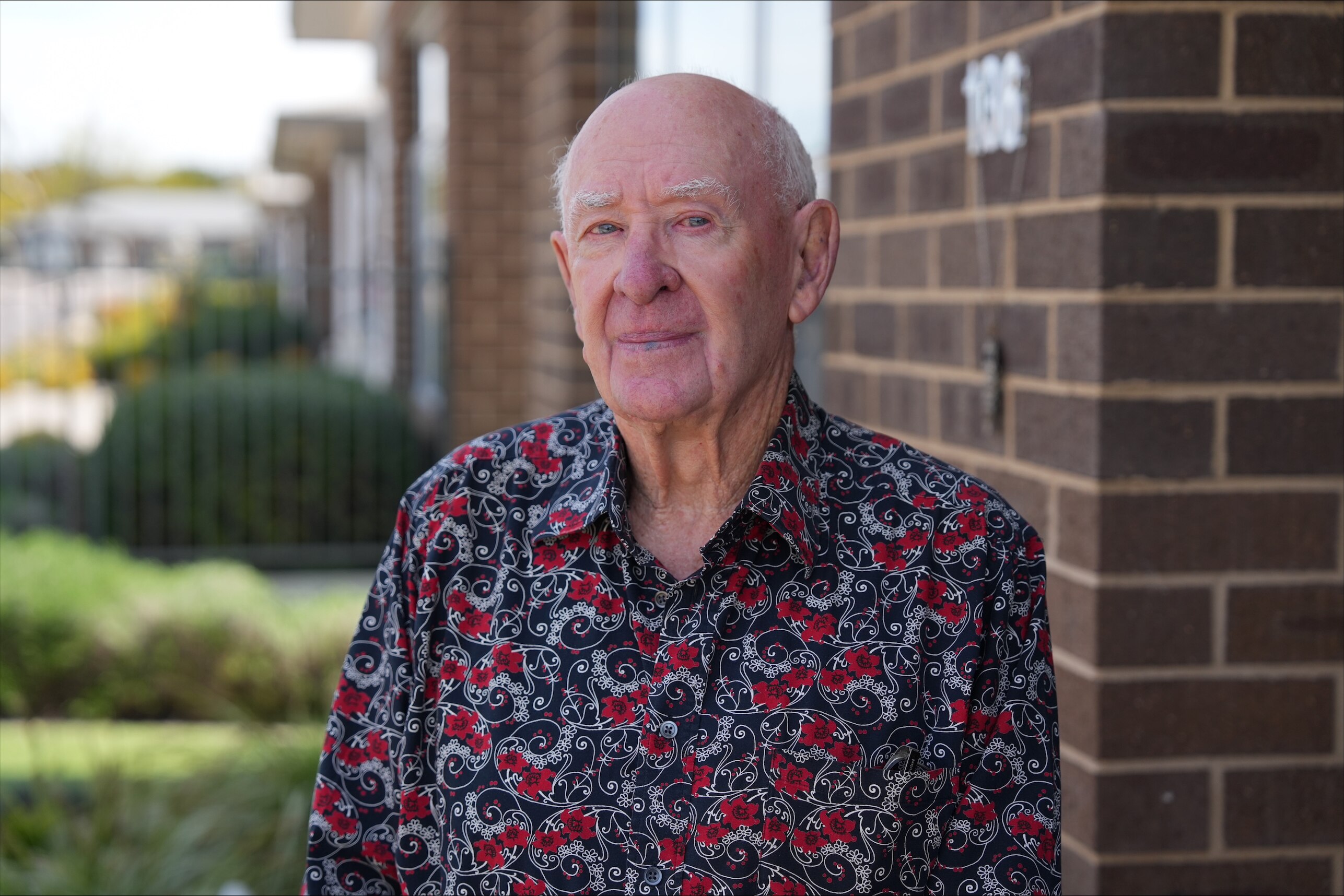 an elderly man in a colourful shirt