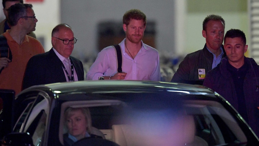 Prince Harry and entourage getting into a car.