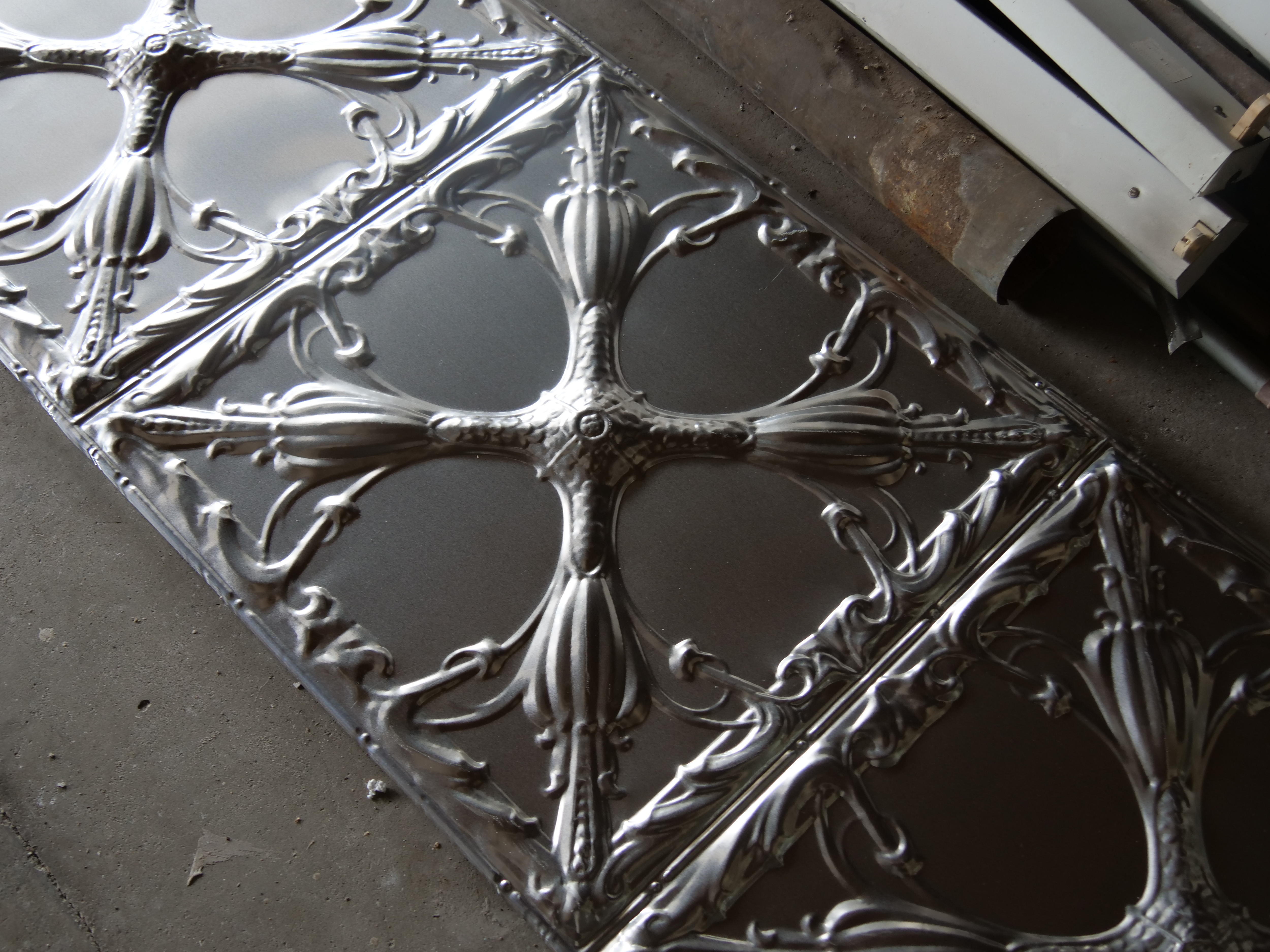 A silver piece of pressed metal filled with beautiful patterns.