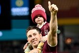 Ben Hunt gives a thumbs up while a child rides on his shoulders after State of Origin III.
