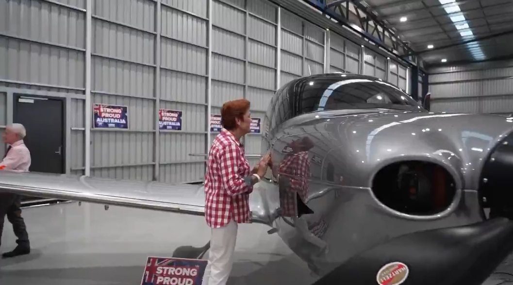 Pauline Hanson peers into the cockpit of a light aircraft.