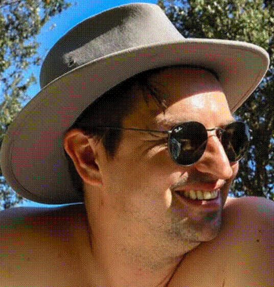 Primer plano de un hombre que llevaba un sombrero gris y gafas de sol oscuras