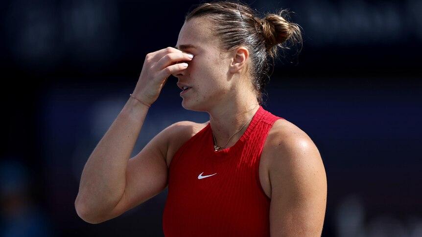 Aryna Sabalenka holds her nose during a match in Dubai as she shows her frustration.