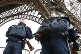 Police take up position under the Eiffel Tower the morning after a series of deadly attacks in Paris, on November 14, 2015.