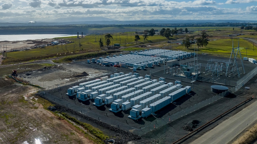 A big battery with a coal mine in the background.