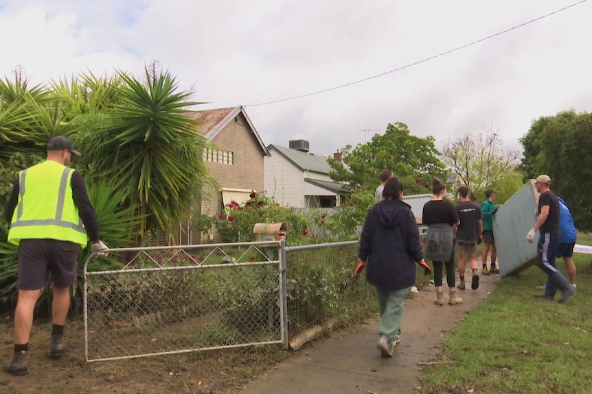 people walking down a street and moving furniture