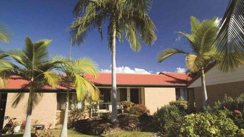 Brick homes set in a among gardens and palm trees at Aveo's Southport Gardens site.