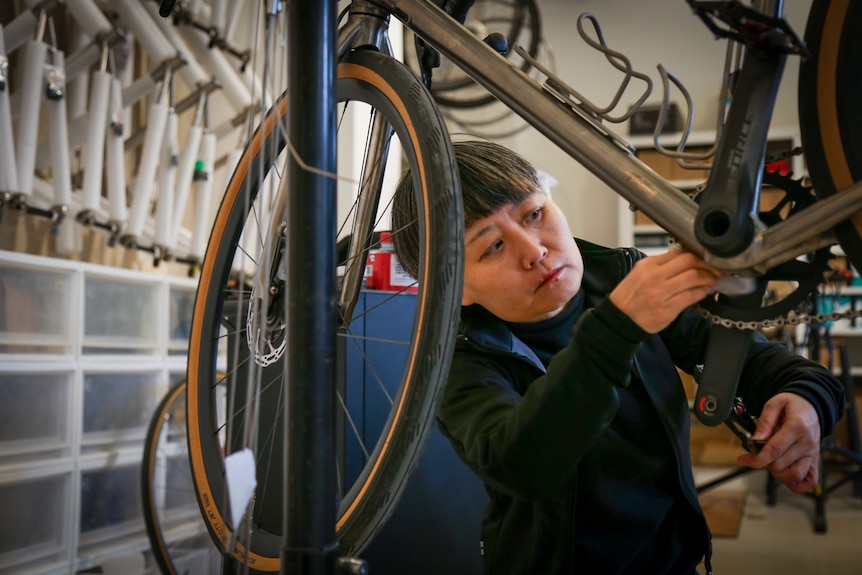 A woman fixing a bicycle 