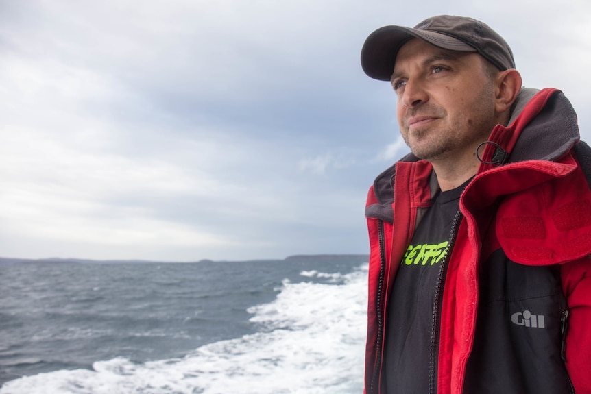 A man on a boat looking out into the distance.