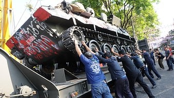 An armoured personnel carrier vehicle is loaded onto a trailer next to Democracy monument in Bangkok after it was stranded du...