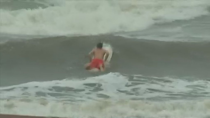 A surfer takes to the waves whipped up by Hurricane Harvey
