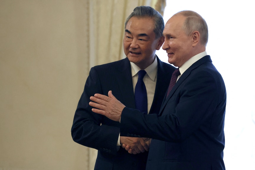 中国外长王毅与俄罗斯总统普京握手、合影。