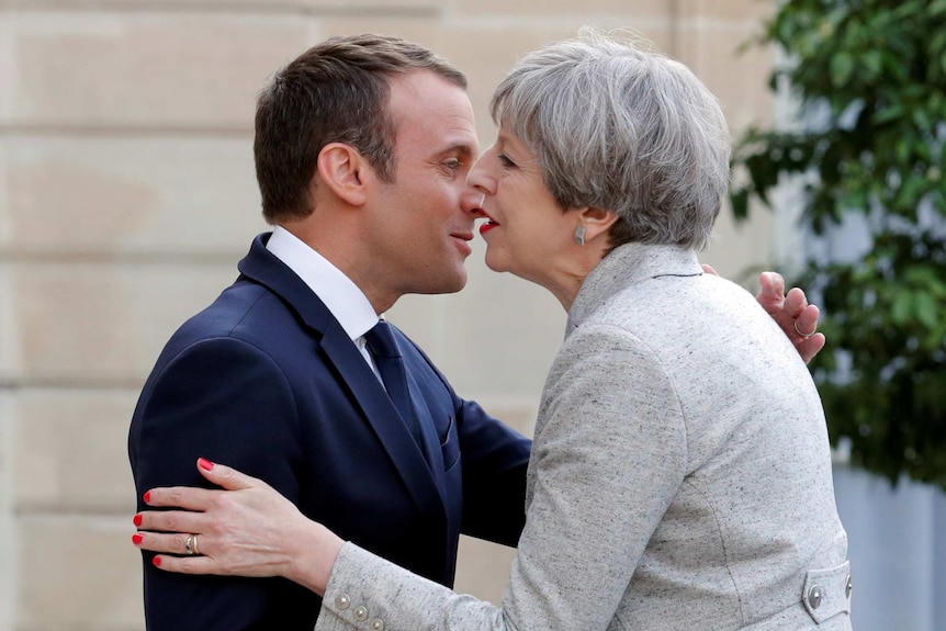 Macron and May greet each other up close.