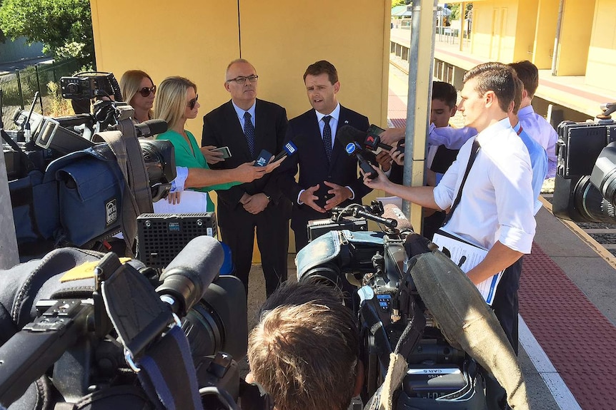 Minister Stephen Mullighan speaks to the press at a train station.