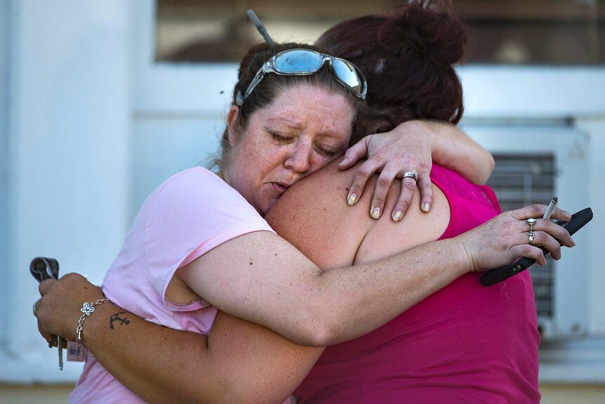 Two women embrace after a fatal shooting at the First Baptist Church.