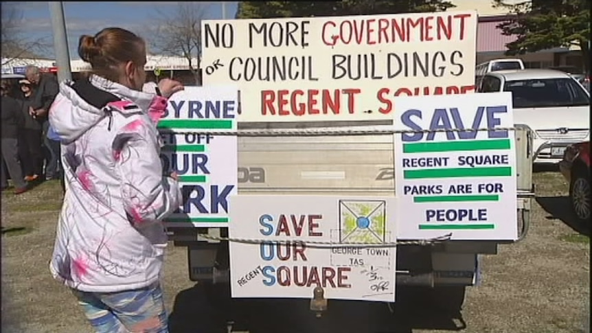 Supporter Danni Cole removes a sign in Regent Square, which was given to the people by Governor Macquarie 200 years ago.