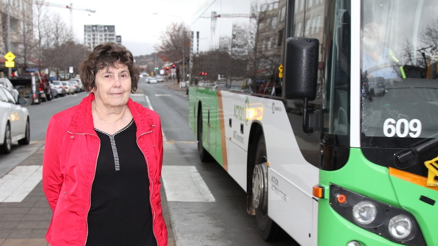 Glenys Patulny stands on Anketell Street in Tuggeranong as a bus passes.