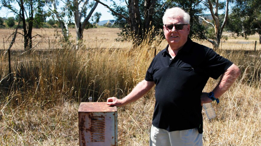 Robert Healy stands beside a short metal box near Queanbeyan.