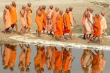 Newly initiated Hindu holy women walk along the Ganges