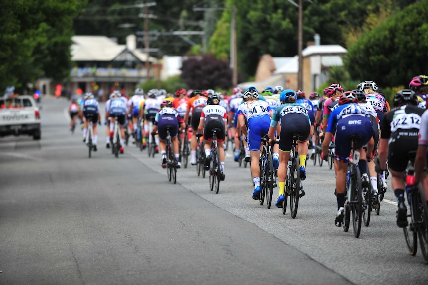 Cyclists ride through a town