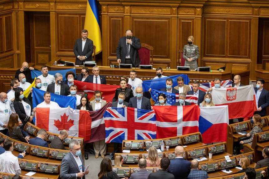 Ukrainian lawmakers hold state flags of Ukraine's partners in parliament to show their appreciation of political support.