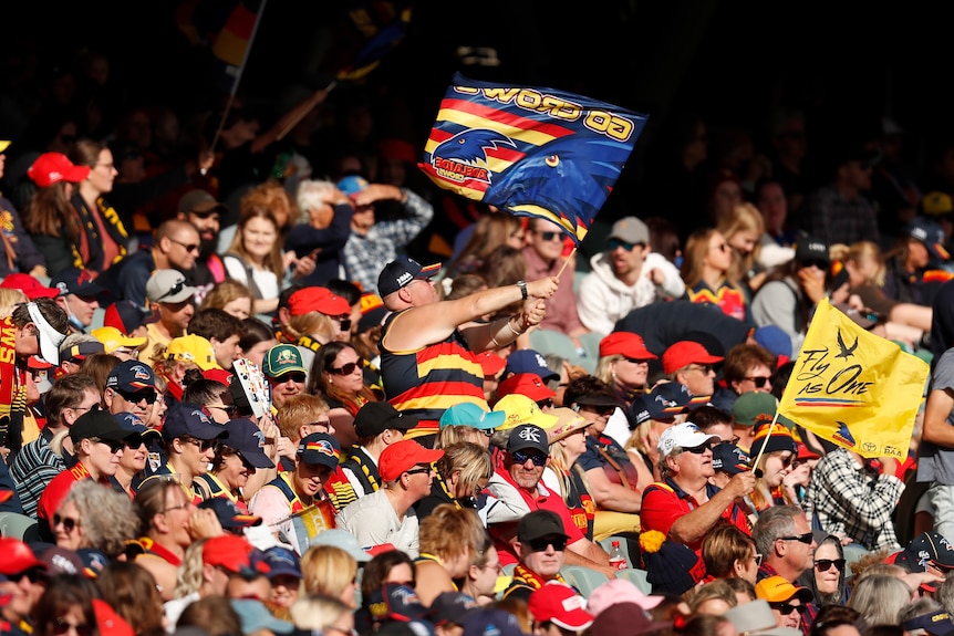 A Crows fan waving his flag during the 2021 AFLW Grand Final match between the Adelaide Crows and the Brisbane Lions 