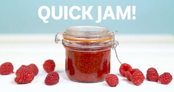 Close up of small jar filled with raspberry chia jam surrounded by fresh raspberries, accompanying our quick recipe