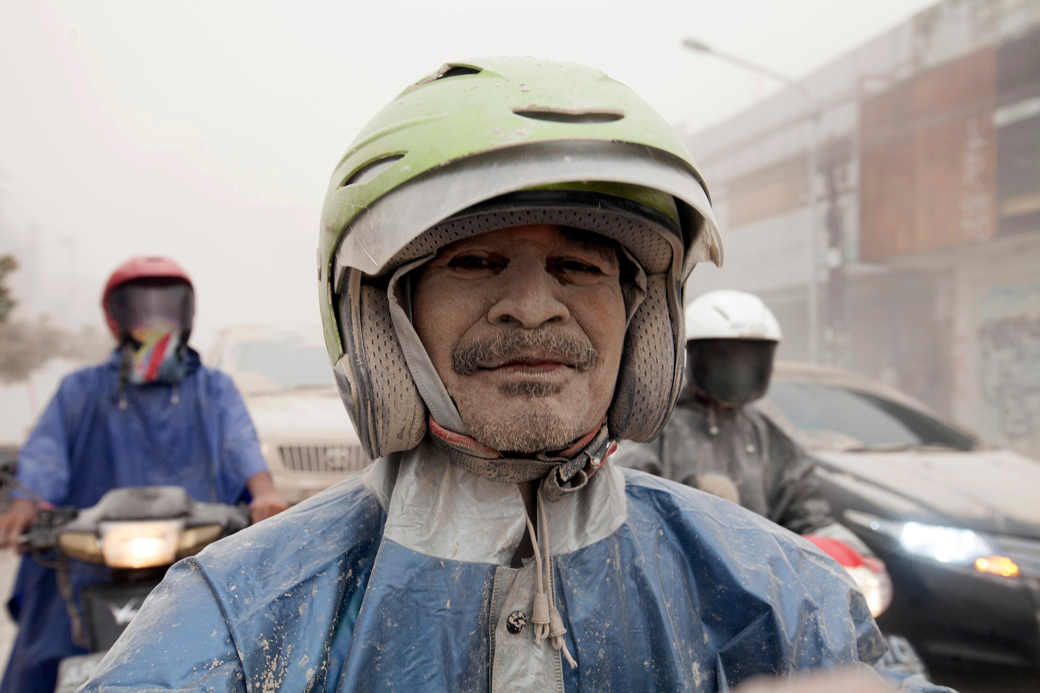 a man wearing helmet covered in ash