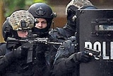 Armed police outside a door