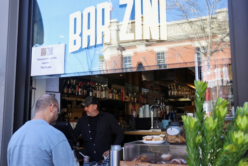 A patron stands in front of a line at Bar Zini 