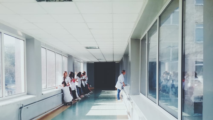 Medical students gathered in a hospital hallway.